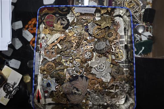 A large collection of military caps and tunic badges (some framed)